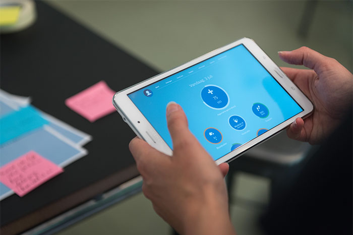 eine Person, die ein Tablet h&auml;lt