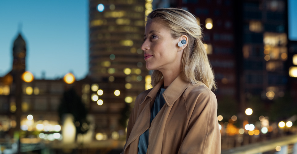 Frau mit Noise Cancelling In-Ear-Kopfh&ouml;rern von Philips unterwegs in der Stadt