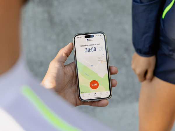 Ein Teilnehmer am Lauf checkt sein Telefon und wartet auf den Startschuss f&uuml;r den Lauf.