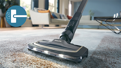 Der kabellose Philips AquaTrio Nass- und Trockensauger 9000 Series reinigt einen Teppich und einen L&auml;ufer