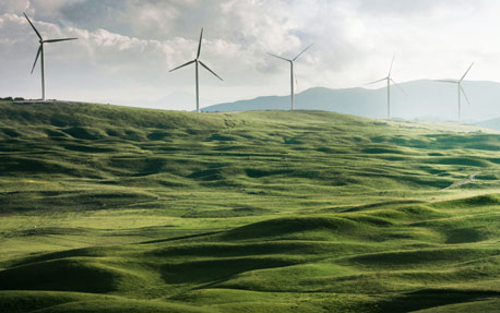 Ein Windpark mit gr&uuml;nen H&uuml;geln, der f&uuml;r saubere Energie und Nachhaltigkeit in Unternehmen steht